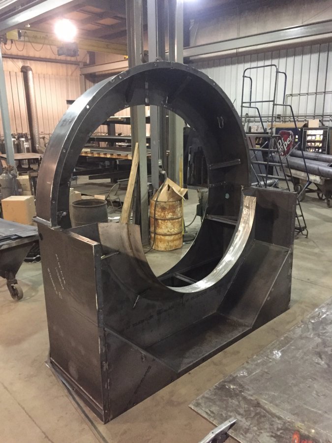 design-build006 A custom-fabricated large-diameter steel ring housing or fan casing with internal structural ribs, staged on a workshop floor at Lee Industries.