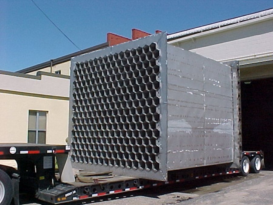 design-build008 A massive, custom-fabricated industrial heat exchanger or radiator core featuring a dense honeycomb structure, staged on a flatbed trailer for transport from Lee Industries.