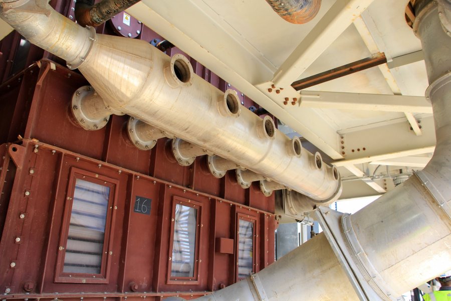 ductwork005 A detailed view of a custom-fabricated industrial manifold with multiple branch connections installed on a large red processing unit.