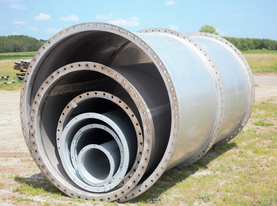 ductwork006 Multiple sizes of large-diameter stainless steel industrial pipes nested together on an outdoor gravel lot at Lee Industries.